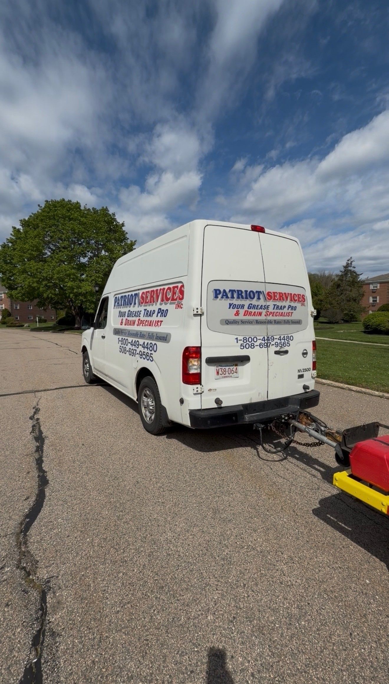 White van parked on a gravel driveway under a partly cloudy sky, with a tree and lawn nearby.
